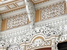 Будинкова різьба (32 фото): прикрашення зовнішнього вигляду будинку прорізній різьбленням, приклади малюнків і накладних елементів різьблених фасадів, технологія роботи по дереву