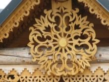 Будинкова різьба (32 фото): прикрашення зовнішнього вигляду будинку прорізній різьбленням, приклади малюнків і накладних елементів різьблених фасадів, технологія роботи по дереву