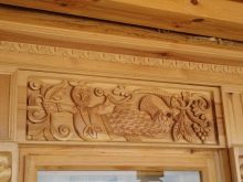 Будинкова різьба (32 фото): прикрашення зовнішнього вигляду будинку прорізній різьбленням, приклади малюнків і накладних елементів різьблених фасадів, технологія роботи по дереву